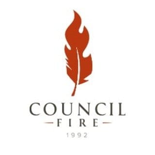 Council Fire current mark, a burnt rust feather whose upper barbs part into flames, above COUNCIL FIRE in letterspaced capitals and the year 1992